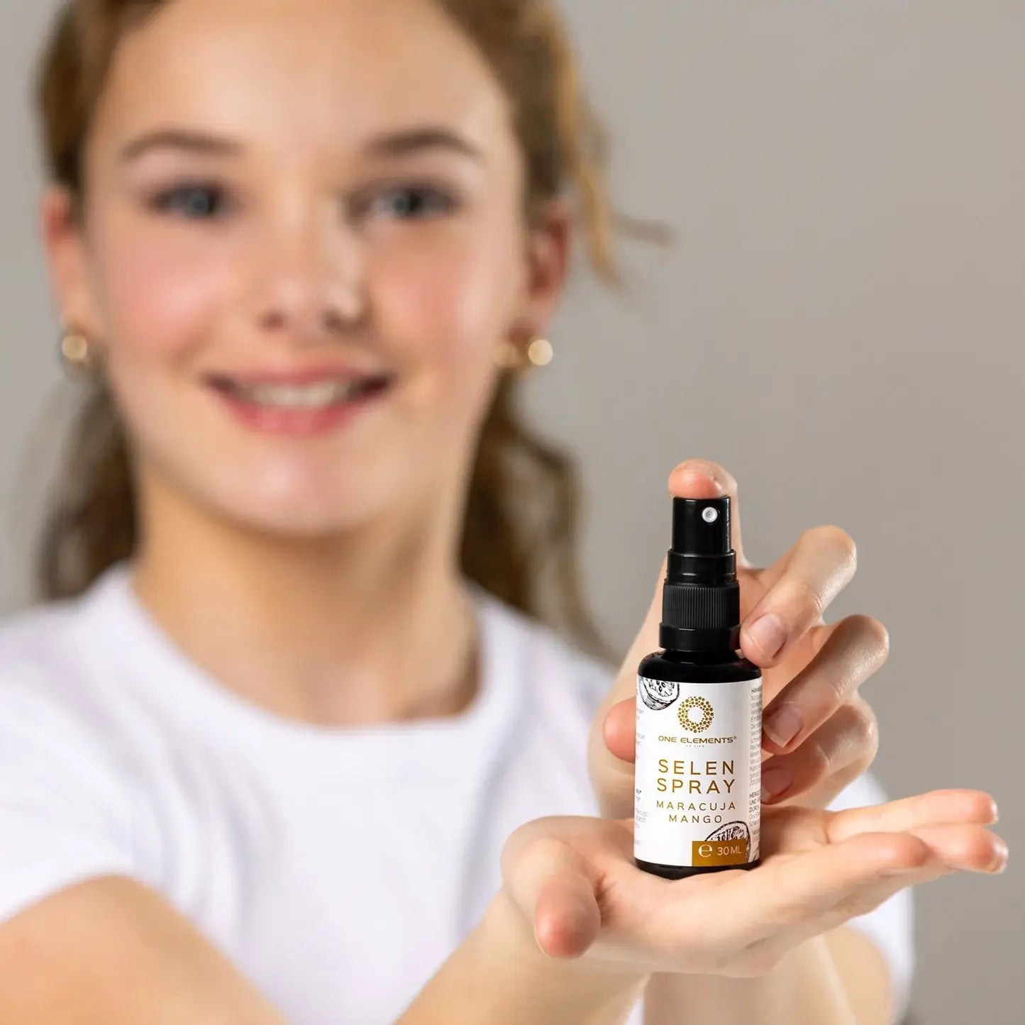 selen_spray_30ml_oneelements_picture_girl_model_nicesmile_spray-in-hand_eruca.ch